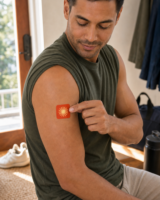 The same man placing an Energy Patch on his upper arm