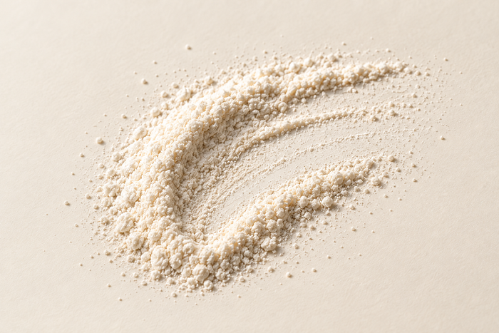 A crescent of fine off-white powder on ivory, illustrating GABA.