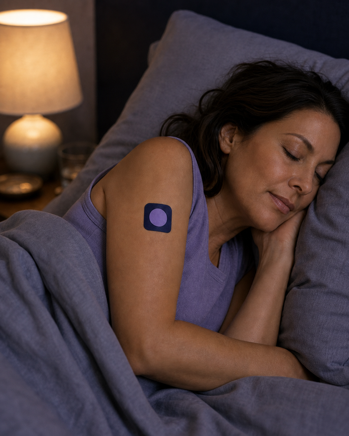 The same woman sleeping with a Pure Patch Sleep Patch visible on her upper arm