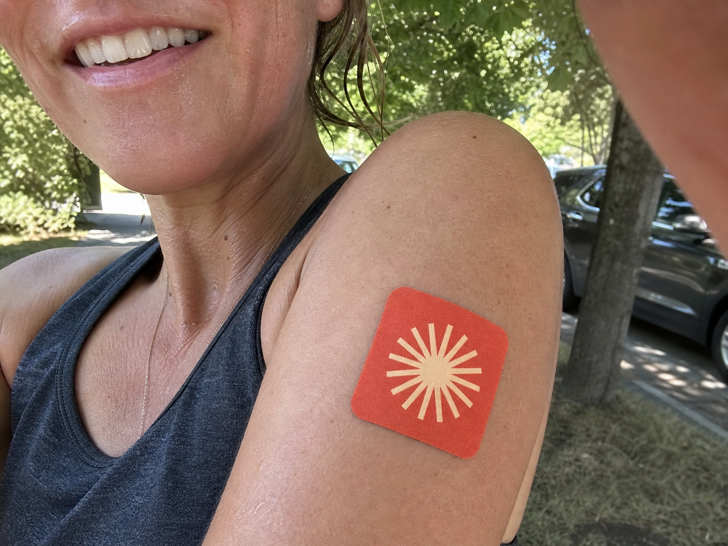 Woman outdoors wearing a Pure Patch Energy Patch on her upper arm.