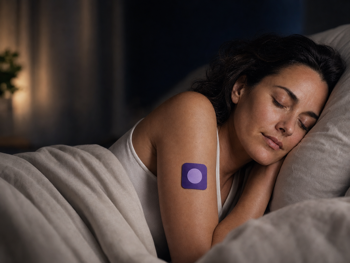 Woman sleeping with a Pure Patch Sleep Patch on her upper arm
